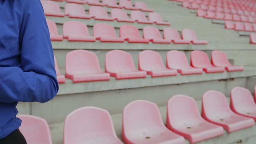Athletic fitness woman take a break and to drink water at the stadium