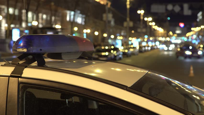Blinking police flasher on the roof of the patrol car at night