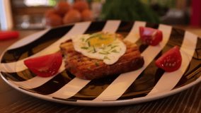 Close up showing avocado toast with eggs and cooked bacon on a wooden table