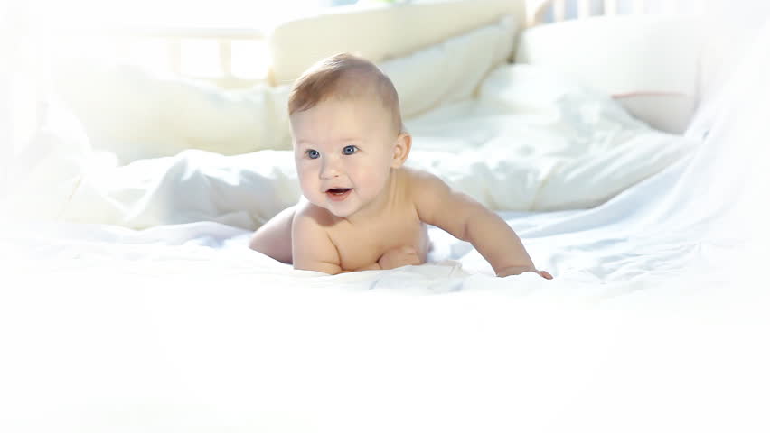 Happy baby playing on the bed