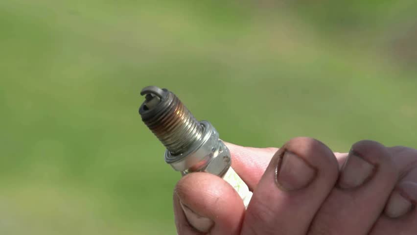  New Zealand. October 2012. Marine mechanic rotating and checking spark plug for