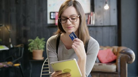 Young Woman Holding Her Credit Card About To Make An Online Shopping Purchase On An iPad Digital Ecommerce Making A Decision For Online Payment Concept Slow Motion Shot On Red Epic 8K