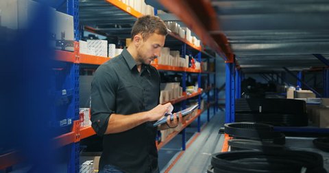Man in a warehouse is checking inventory levels of goods, using his tablet, Last in last out, First in first out concept photo, orange-blue perspective background