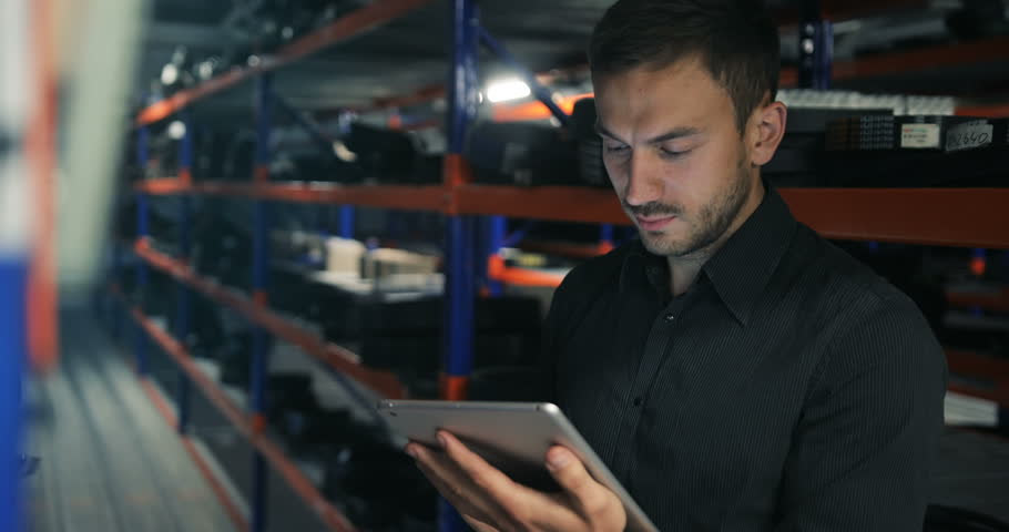 Serious strict warehouse manager using tablet pc in a large warehouse perspective Royalty-Free Stock Footage #28457680