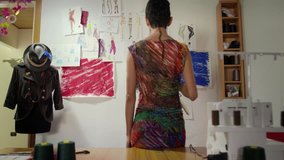 Hispanic woman at work as fashion designer and tailor, looking at sketches in atelier. Sequence - Powered by Shutterstock - Get 15% off with code: PIKWIZARD15
