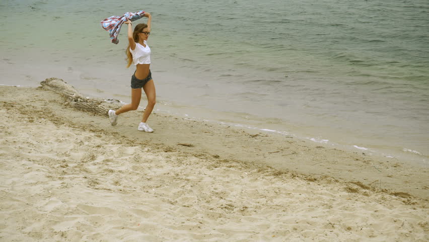 cute young blonde runs on a seashore