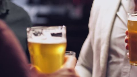 Cropped video of young men friends drinking beer and talking with each other in bar