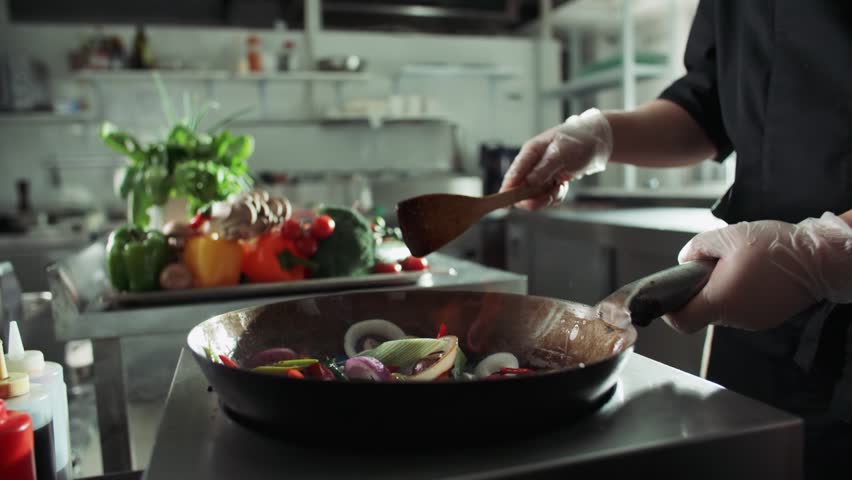 close-up of a chef working the wok with flames roasting mixed colorful vegetables tossing them , restaurant kitchen , slow motion Royalty-Free Stock Footage #28469842