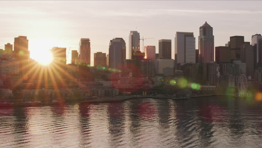 Seattle, Washington circa-2017, Sun peeks out from behind downtown Seattle buildings at sunrise. Shot with Cineflex and RED Epic-W Helium.
