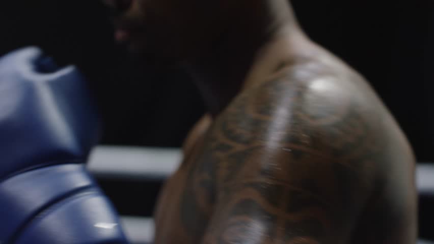 Man with Boxing gloves Boxing in front of the camera close up. Close-up of young man punching. Boxer performing uppercut on black background Royalty-Free Stock Footage #28478632