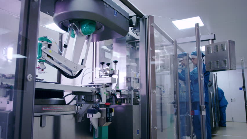 Engineer starting packaging line at pharmaceutical plant. Pharmaceutical manufacturing line. Factory worker at industrial workshop. Pharmaceutical industry