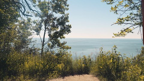 Slider shot from a cliff looking out at the lake and horizon. 4K UHD.