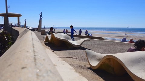 CLEVELEYS, ENGLAND, UNITED KINGDOM - JUNE, 2017: View of people, families with children relaxing on a sunny day on promenade of English seaside resort town.