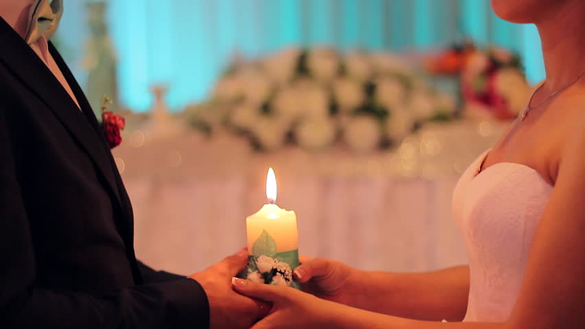 Just married the couple the hold burning candle in their hands. | Shutterstock HD Video #28493839