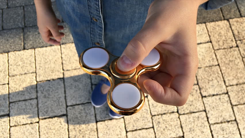 Gold spinner in hand. Popular trendy toy close-up.