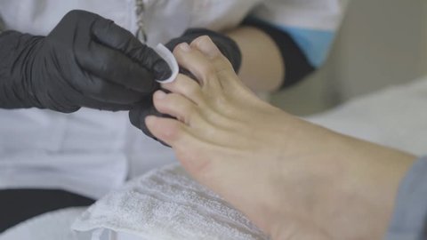 Cleaning nails before using nail polish. Pedicure with a professional drill machine by using different drill bits. Peeling feet pedicure procedure.