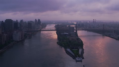 New York City circa-2017, Flying up East River over Roosevelt Island and Queensboro Bridge at sunrise. Shot with Cineflex and RED Epic-W Helium.