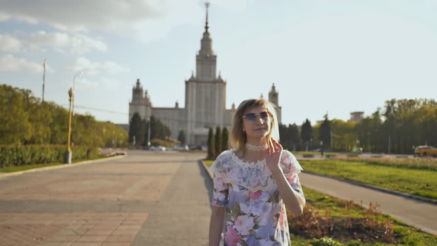 Young young blonde girl is happy on a warm summer evening in the park.