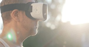 Man using virtual reality headset at garden 4k, sun lens flare dad