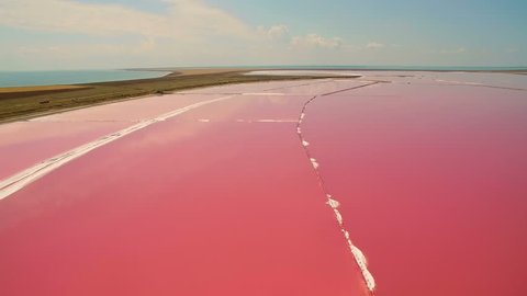 Aerial view of salt sea water evaporation ponds with pink plankton colour
