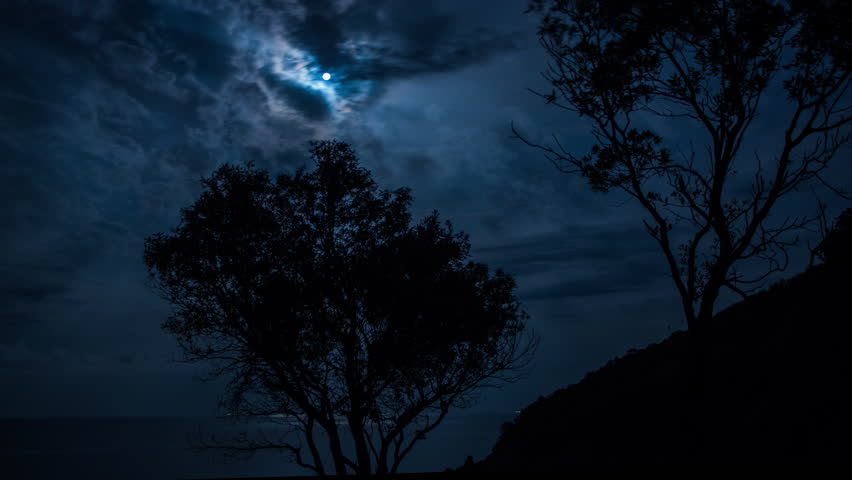 night time timelapse during a large moon over the sea in sicily, italy