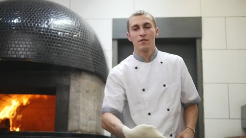 Chefs rotate pizza dough in the air.