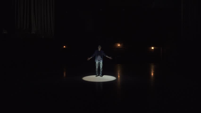 Young adult man posing in white strobe light beam