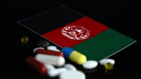 Afghani flag with lot of medical pills isolated on black background - Powered by Shutterstock - Get 15% off with code: PIKWIZARD15