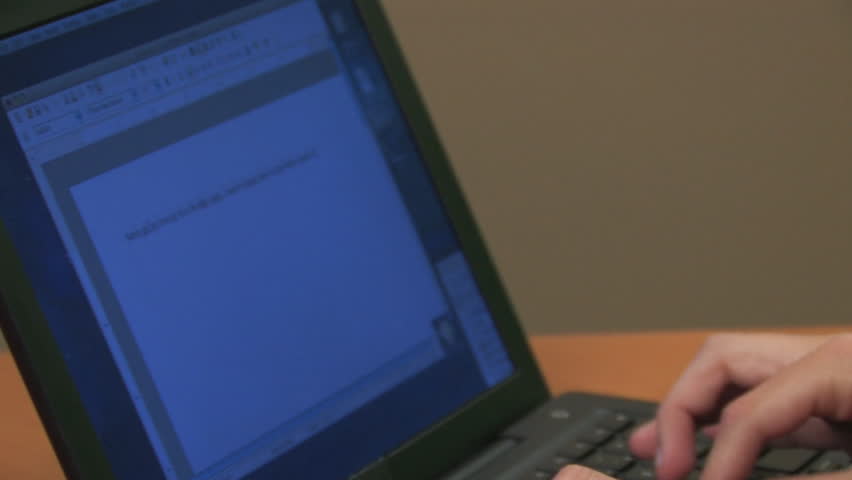A woman types on a black laptop.