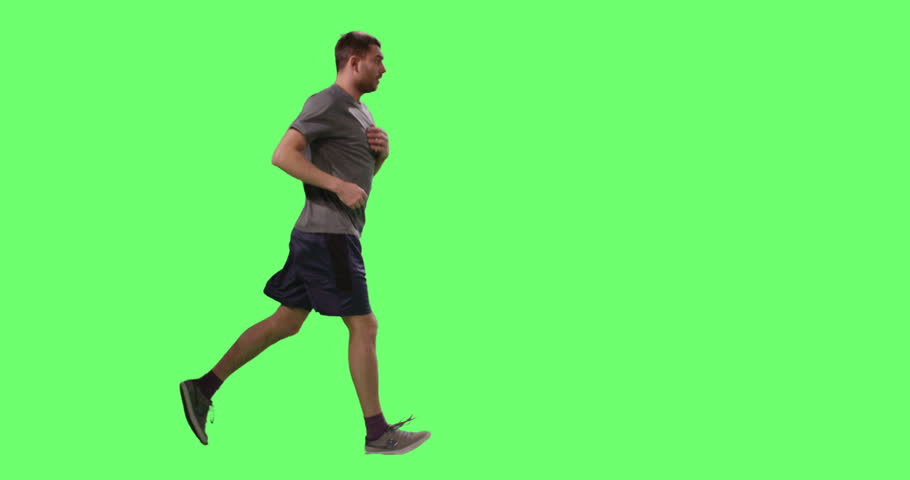 Man in a T-shirt is Jogging on a Mock-up Green Screen in the Background. Shot on RED Cinema Camera in 4K (UHD).