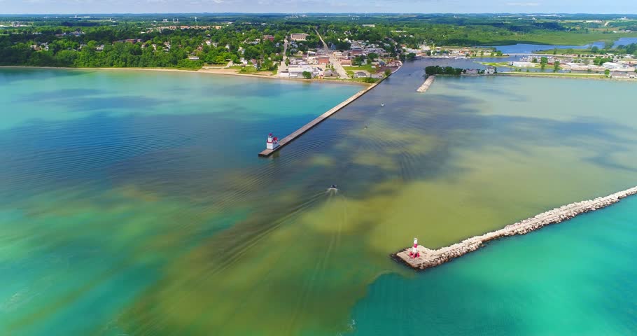 Splendid aerial view of sunlight and moving cloud shadows on Lake Michigan’s beautiful Kewaunee Wisconsin Harbor.