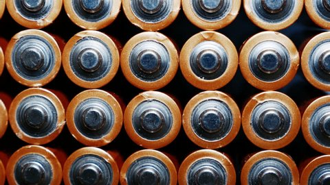 Energy abstract Background of Batteries. The top view of the AA-Size Battery. Used Alkaline Batteries . Close Up