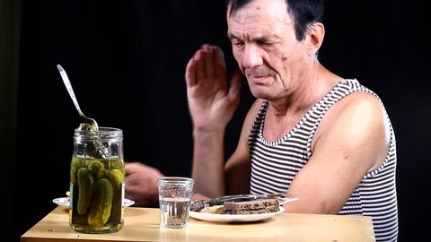 Man drinks and eats pickle