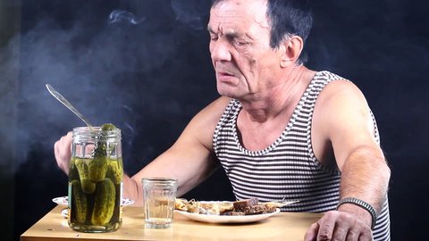 Man drinks, smokes and bites pickle