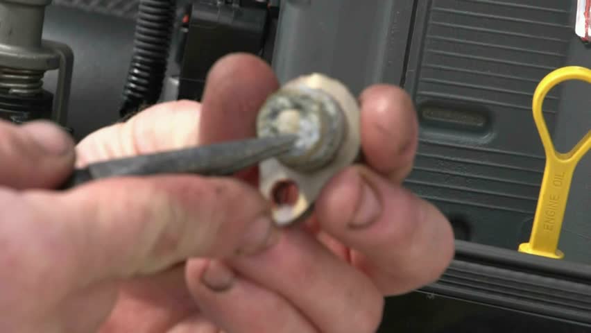 Mechanic scrapes out salt build up and cleans up anode blocks out of marine