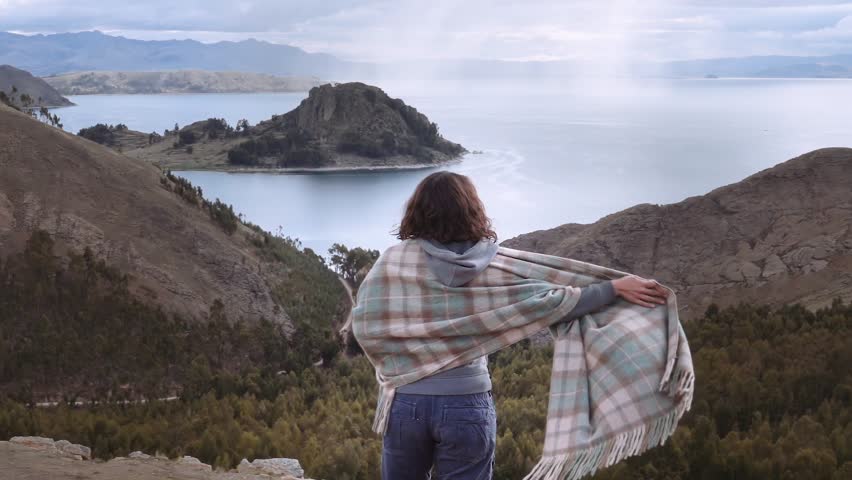 Bolivian woman contemplating beautiful panorama of the lake Titicaca.
