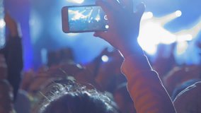 Hands recording video with smart phones at music concert