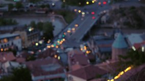 The camera focuses on night old European city view from above. The movement of cars with luminous headlights on the road.
