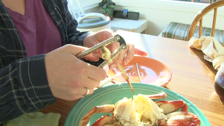 Couple enjoy fresh dungeness crab at dinner table and play with food.