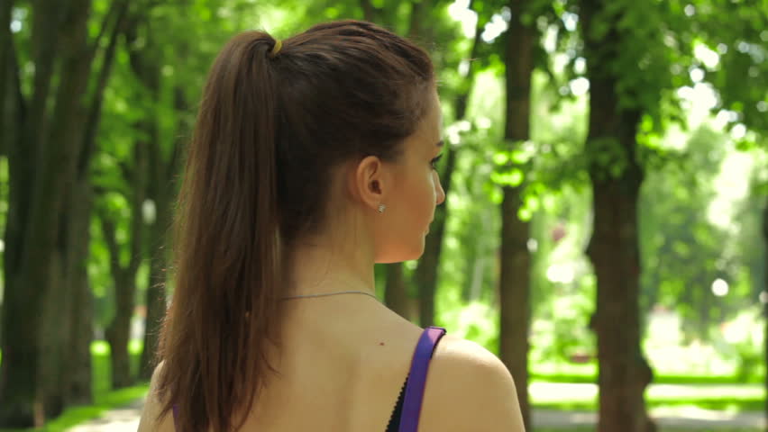 brunette with ponytail inserts in-ear earphones
