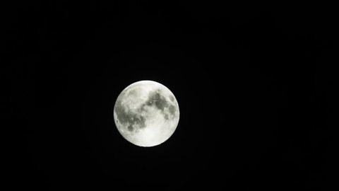 A Moon is rapid moving in the dark sky at night time passed by cloudy