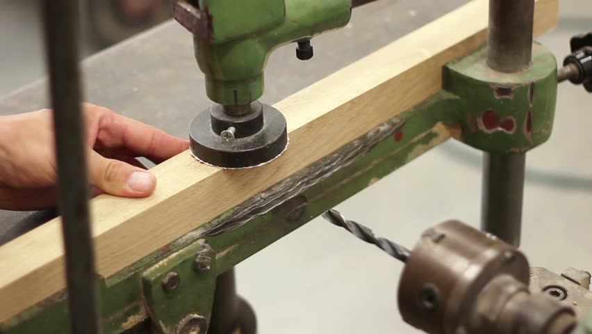 Carpenter working with electric machine, drilling wooden desk (selective focus)