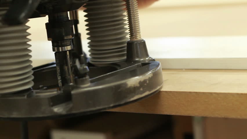 Carpenter working with electric machine, grinding wooden desk (selective focus)
