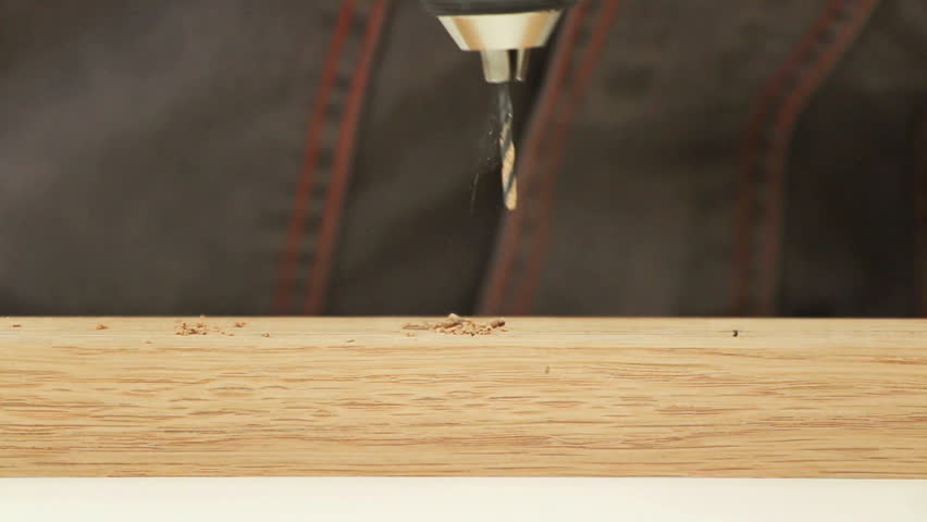 Carpenter working with electric machine, drilling into wooden desk (selective