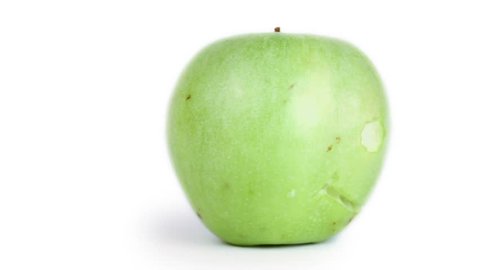 Green apple spins with smiling face carved on it surface isolated closeup
