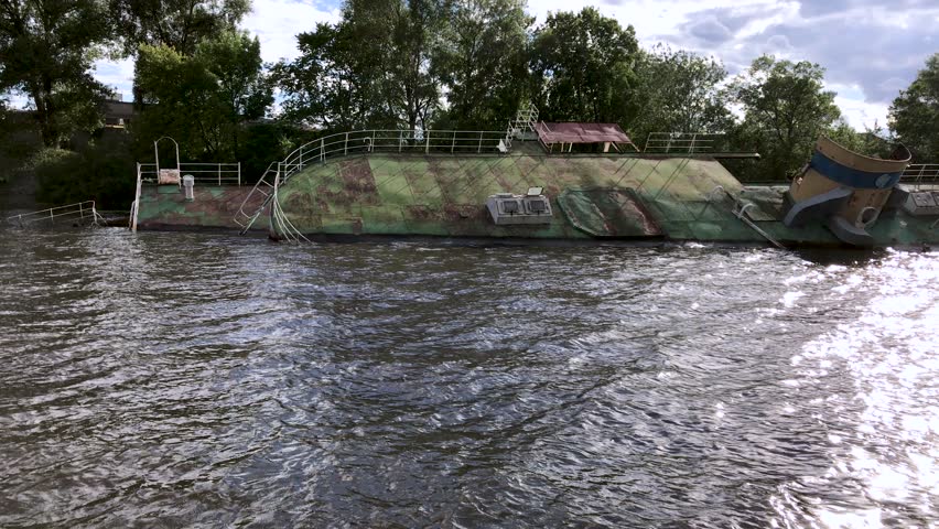 Kiev. Ukraine. July 2017: - Sunken ship near the shore on the Dnieper River, lying on its side, half submerged in water.