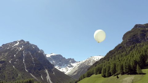 White balloon on the wind with the alps on the background
