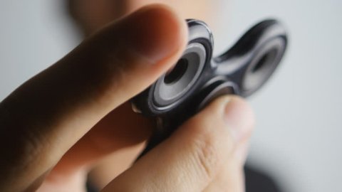 Man playing with fidget spinner. Fidget spinner is a toy which reportedly relieves stress and helps persons with ADD attention deficit disorder concentrate more and study better.