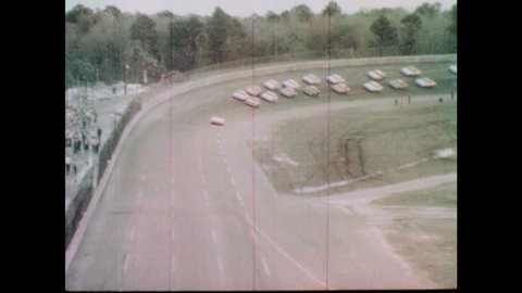 1960s: Pace car pulls off race track. Cars begin race. Cars speed down track.