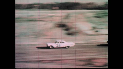 1960s: Race cars speed down track. Cars attempt to pass others.